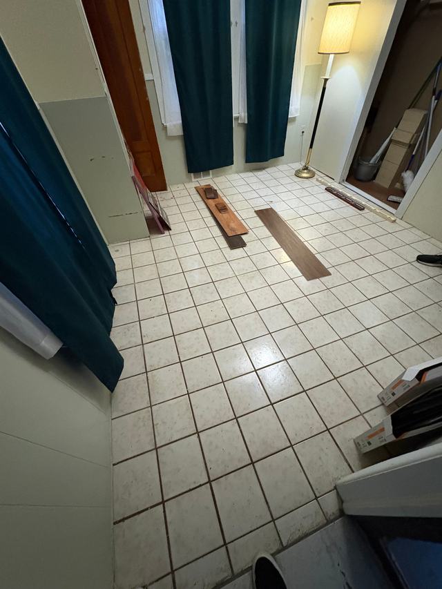 Before: old white tile floor with the first new planks laid out