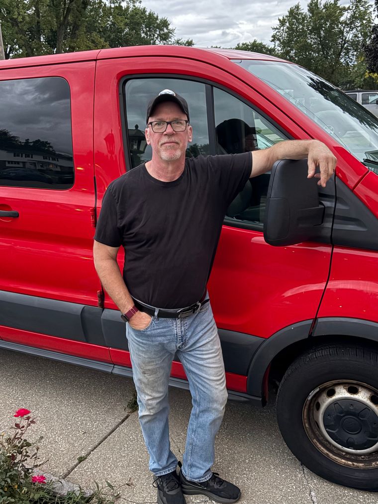 Gary standing beside his red work van