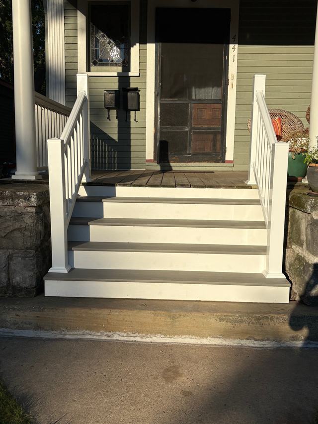 After: rebuilt porch steps with clean white risers, gray treads, and new white railings on both sides
